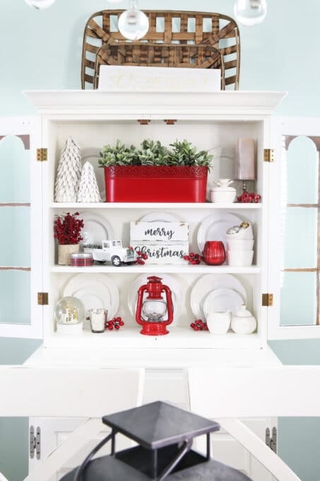 Decorating with white dishes in a hutch with pops of red