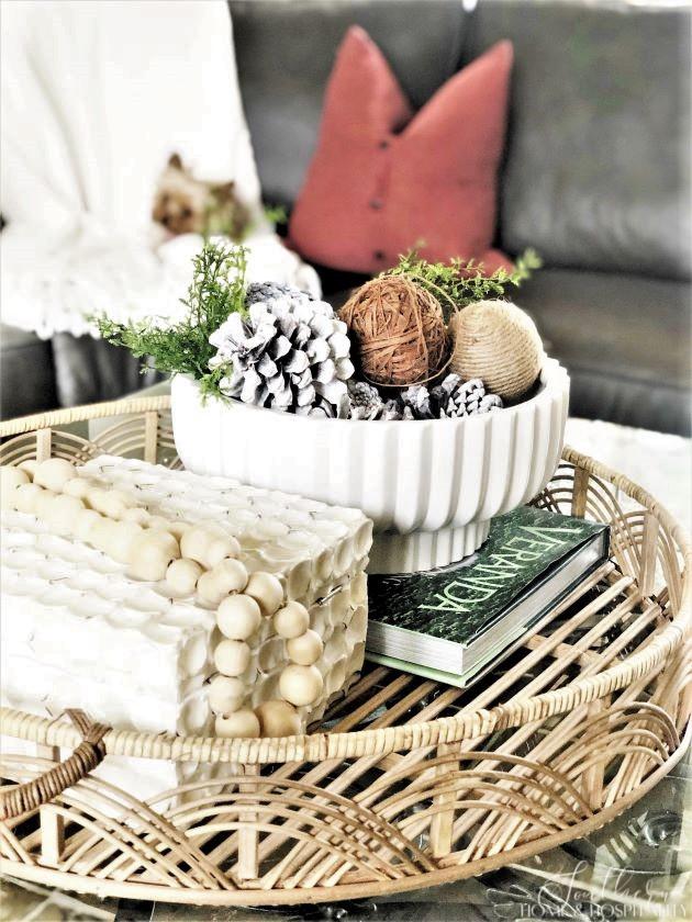 coffee table vignette for winter with rattan tray, bowl with pinecones and natural balls