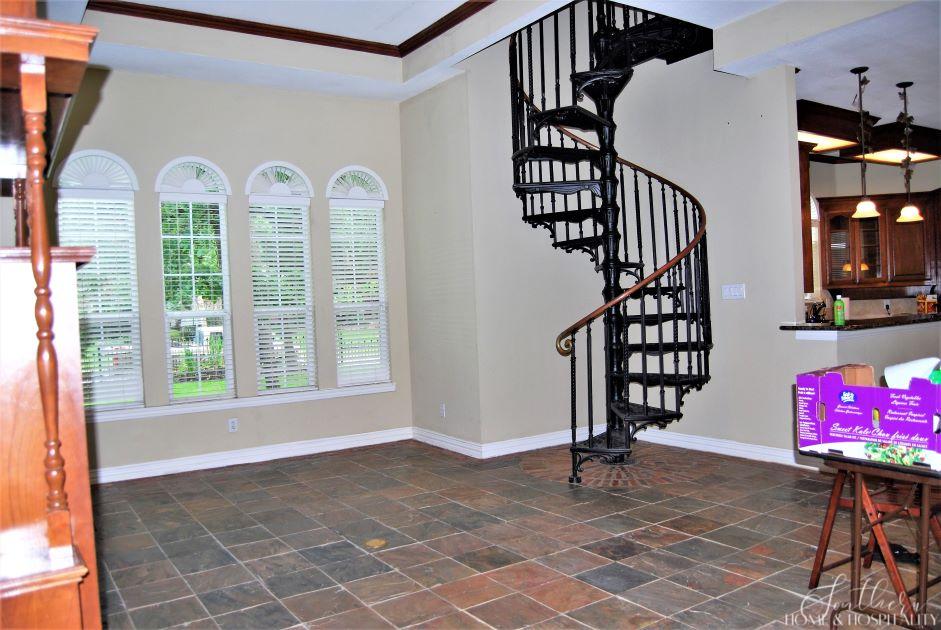 Family room with iron spiral staircase before renovation