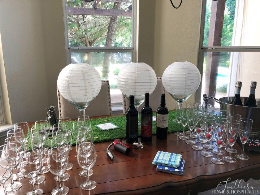 Golf theme party wine station with golf ball centerpieces and artificial grass runner