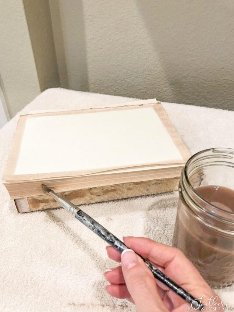 Painting book edges with paint and water mixture to age