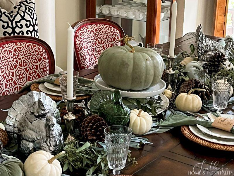 Green, silver, and white pumpkins and turkeys as centerpiece on dining table