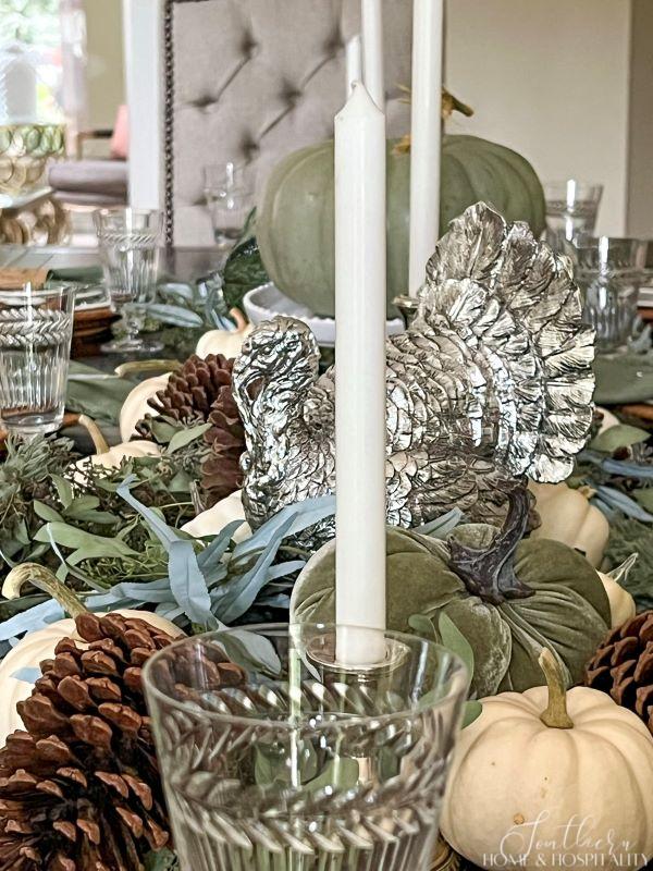 Green, silver, and white pumpkins and turkeys as centerpiece on dining table