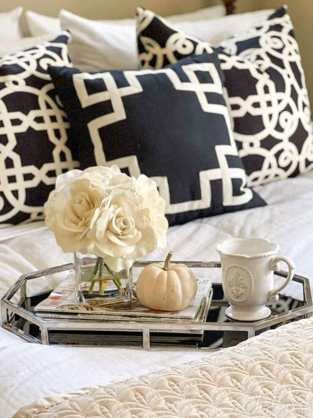 Guest room with tray on bed with flowers and magazines