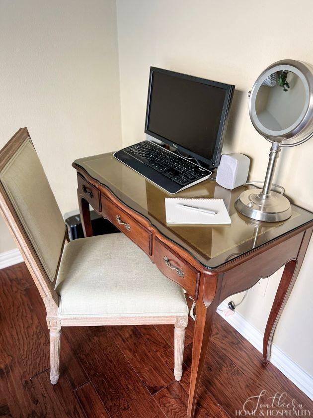 desk with computer and makeup mirror for guests