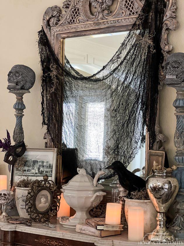 spooky chic gothic halloween dining room sideboard with creepy cloth, skulls, old photos