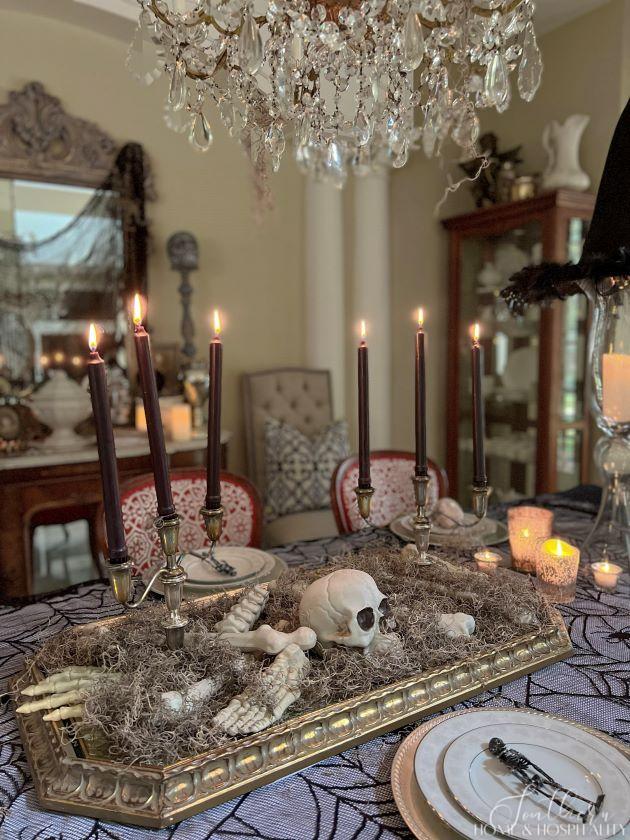 spooky chic gothic halloween dining room centerpiece with skeleton and candles