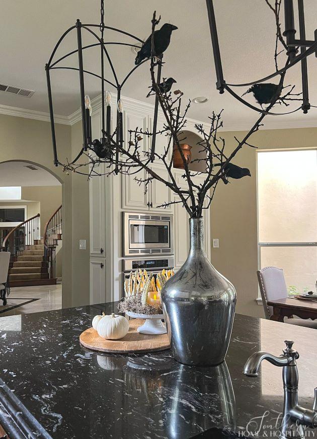 Halloween decorations on kitchen island with birds on tree branches