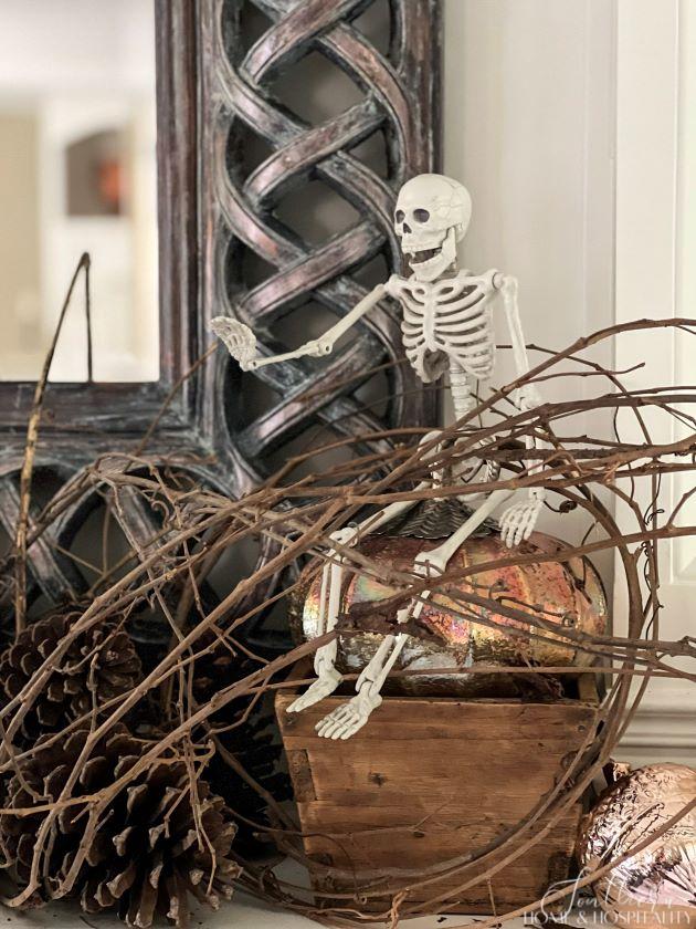 Skeleton on pumpkin on mantel