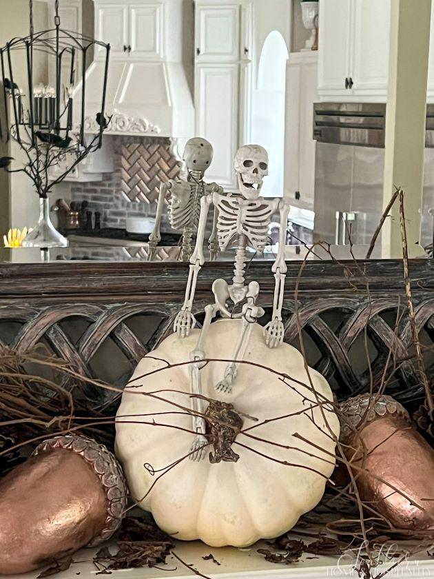 Skeleton on pumpkin on mantel