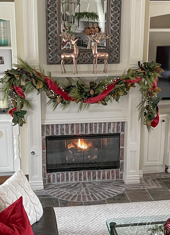 magnolia and pine Christmas garland on fireplace mantel, copper deer, copper pots, garland on vent hood