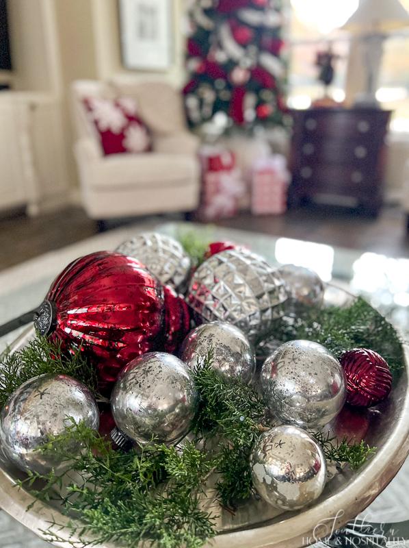red and silver mercury glass ornaments in tray on coffee table