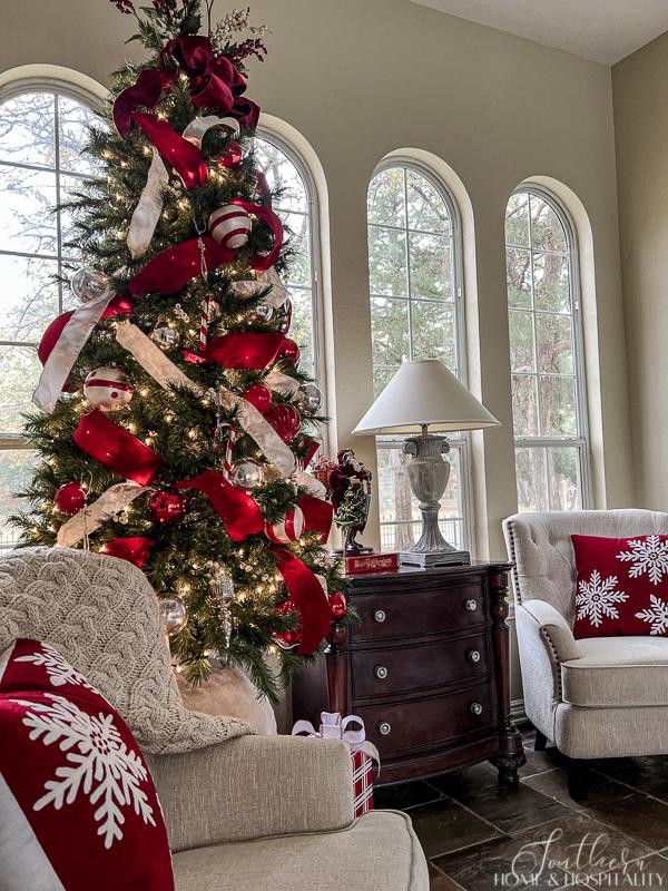 red and white ribbon and ornaments on Christmas tree, red and white snowflake pillows