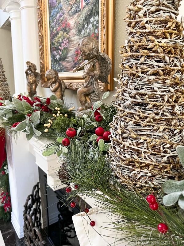 Christmas angel statues with red and white berries and greenery