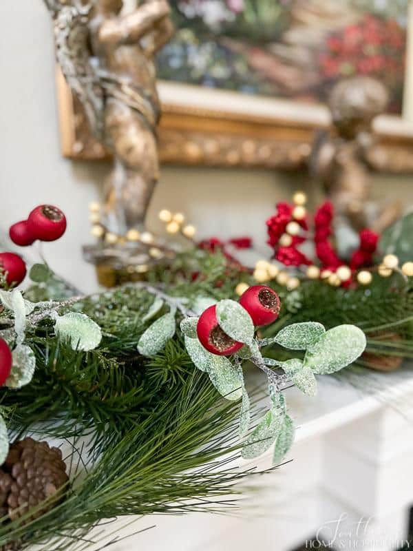 Christmas angel statues with red and white berries and greenery