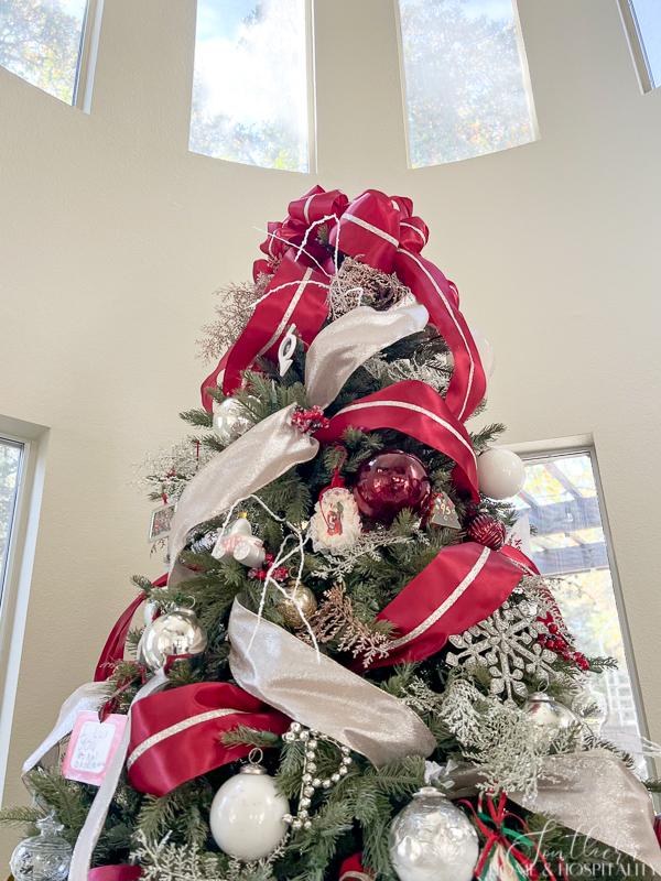 Christmas tree decorated in red, silver, champagne and white ribbon and ornaments