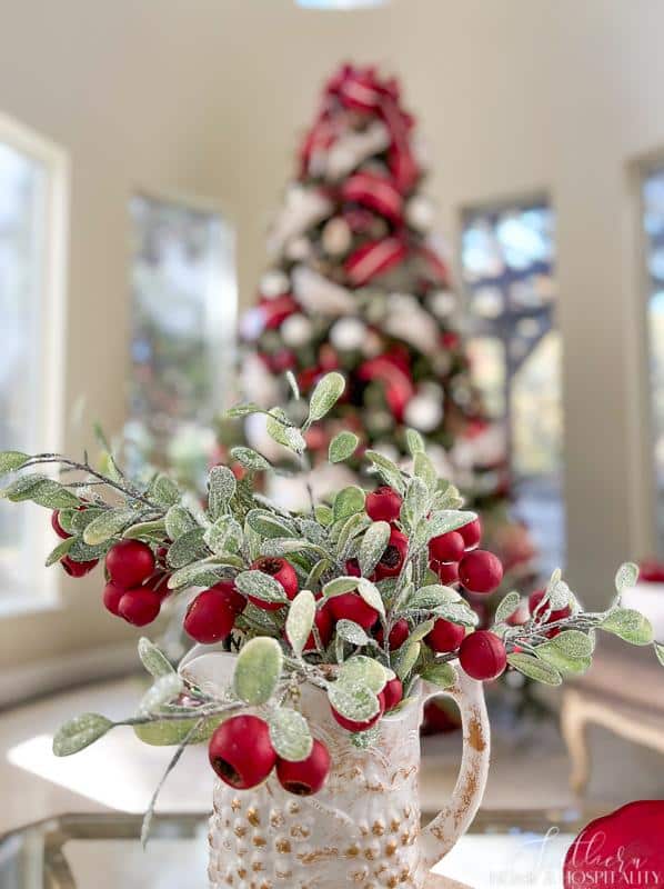 red berries and frosted leaves in white vintage pitcher