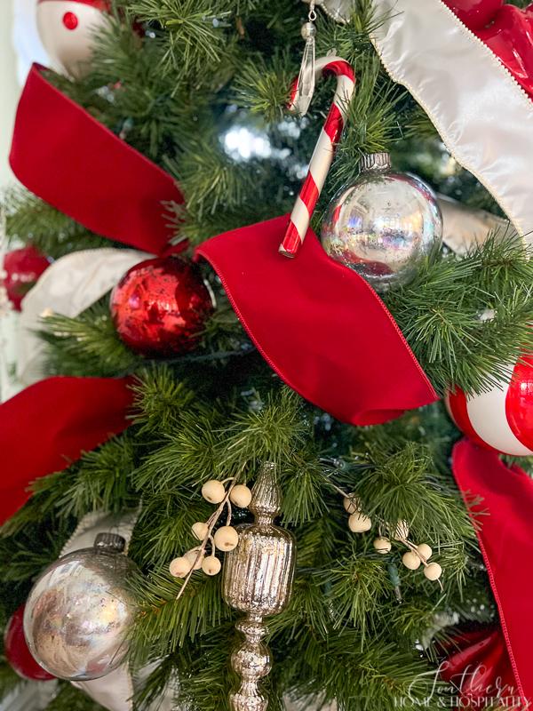 Christmas tree with red and white ribbon and red, silver, and white ornaments