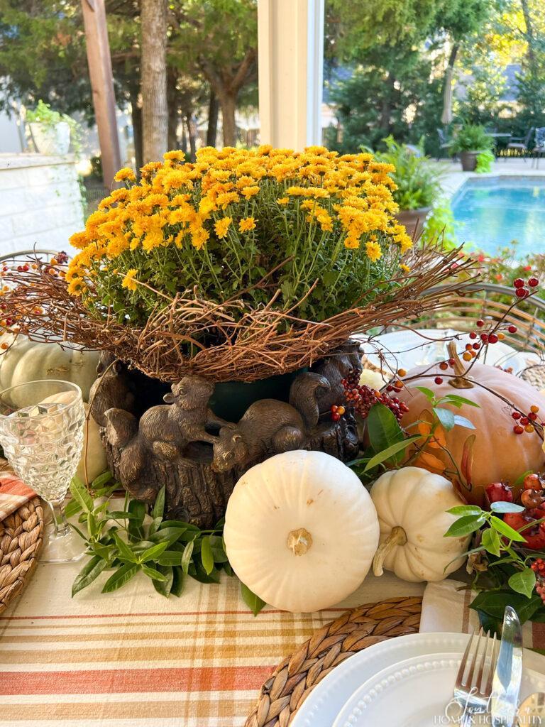 Mums and pumpkins centerpiece on outdoor dining table