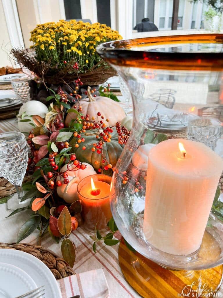 Pumpkins and candles in outdoor fall tablescape
