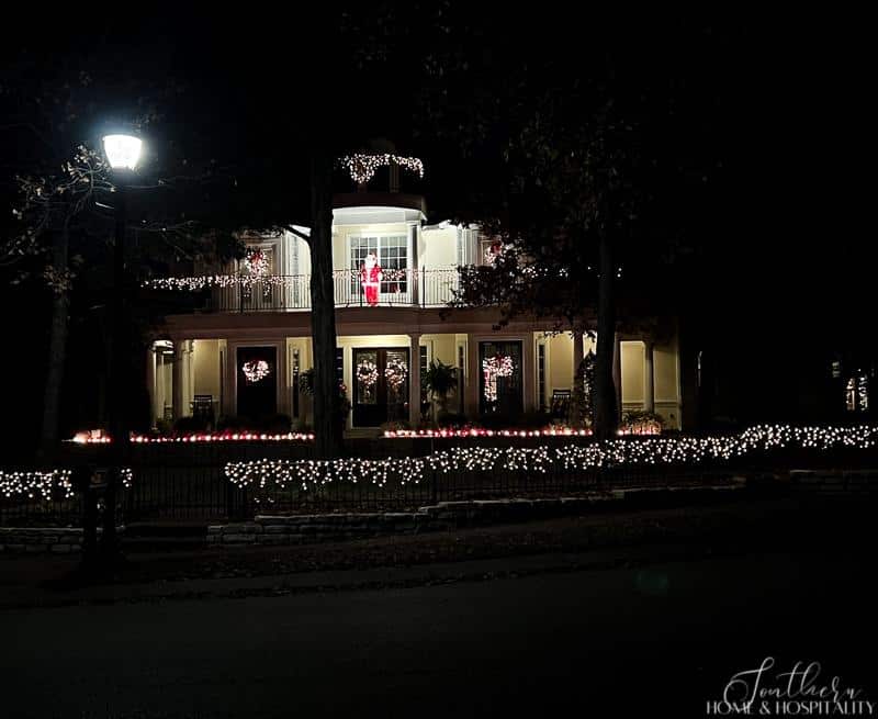 Christmas icicle lights on iron fence in front of southern style house