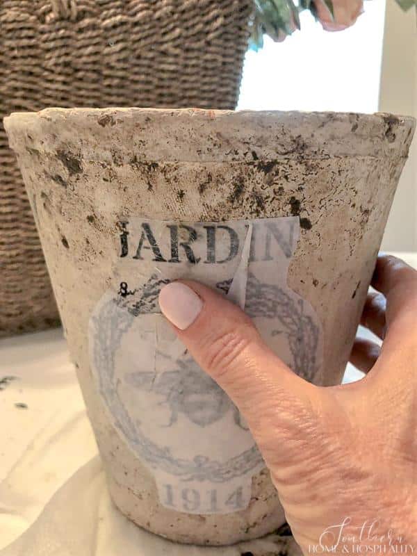 Peeling away paper from transfer on flower pot