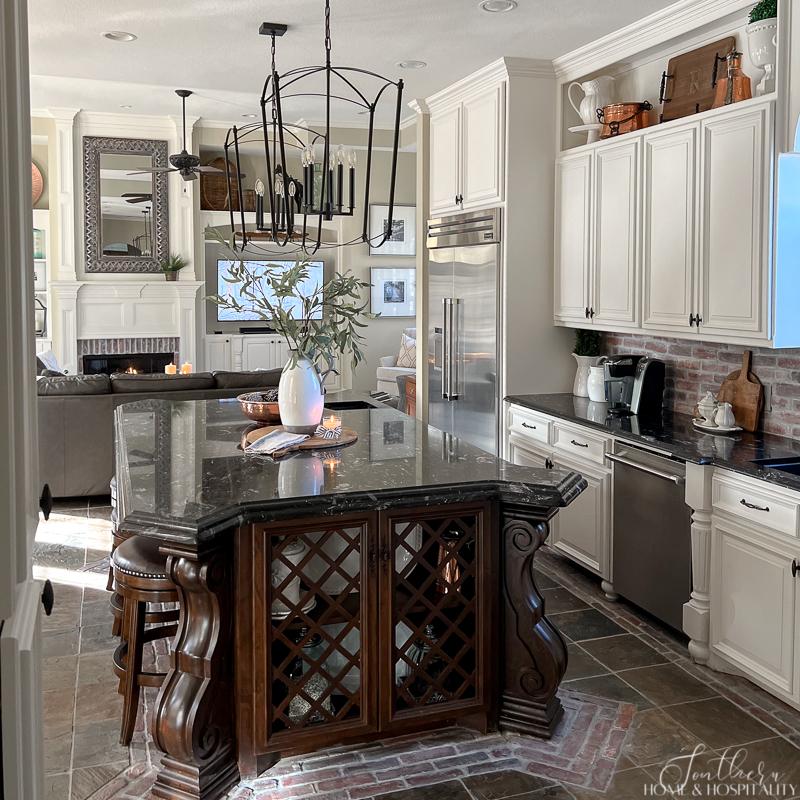 furniture kitchen island with lattice doors, black granite, oversize kitchen pendants brick backsplash