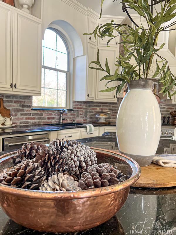 copper bowl with pinecones, brick backsplash, black granite, French country kitchen