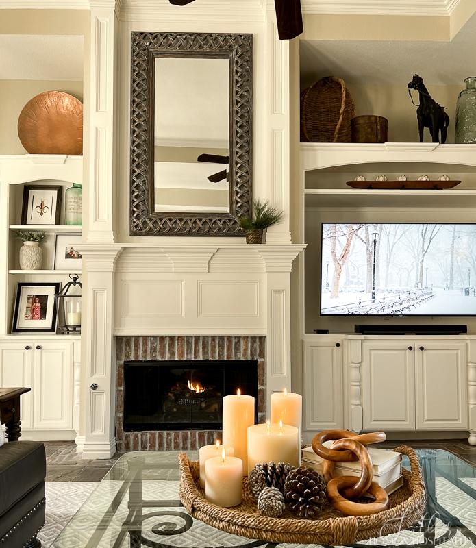 traditional family room with winter decor, winter coffee table vignette with candles, pinecones, winter art on tv