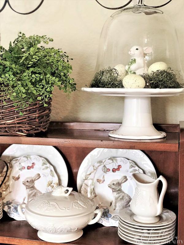 Easter decorations with bunny, eggs, and moss under a cloche