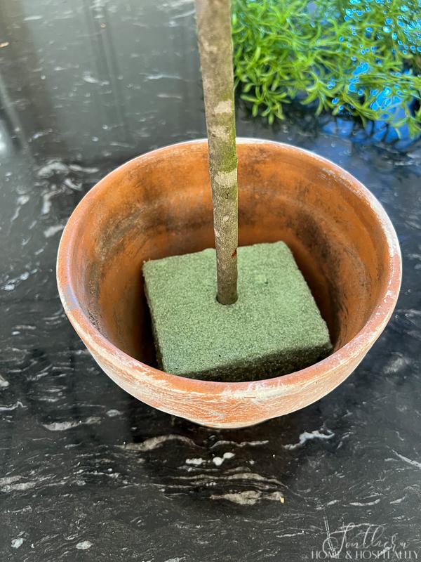 styrofoam with topiary stick in garden pot