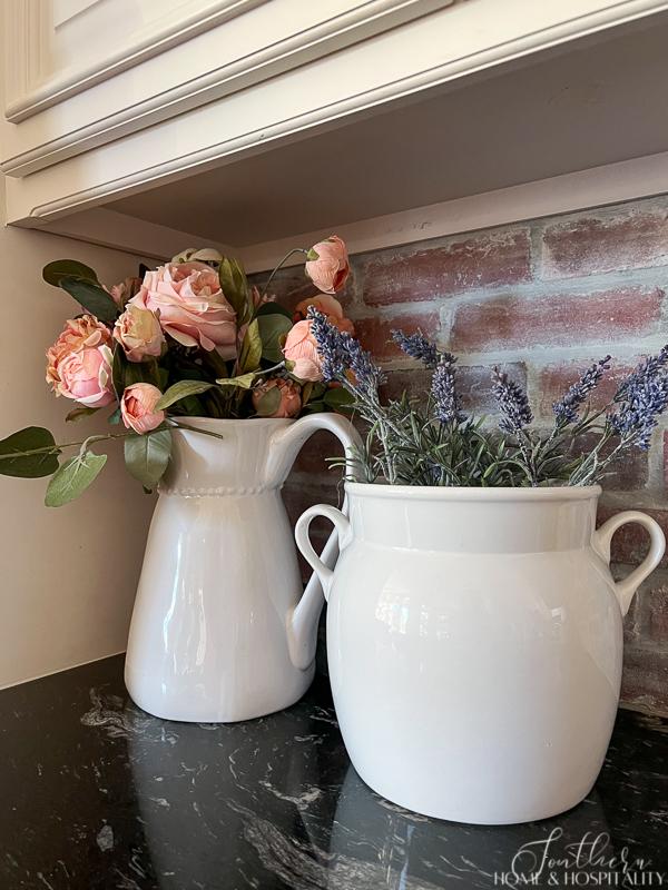 Pink roses and lavender in white pots in French country kitchen