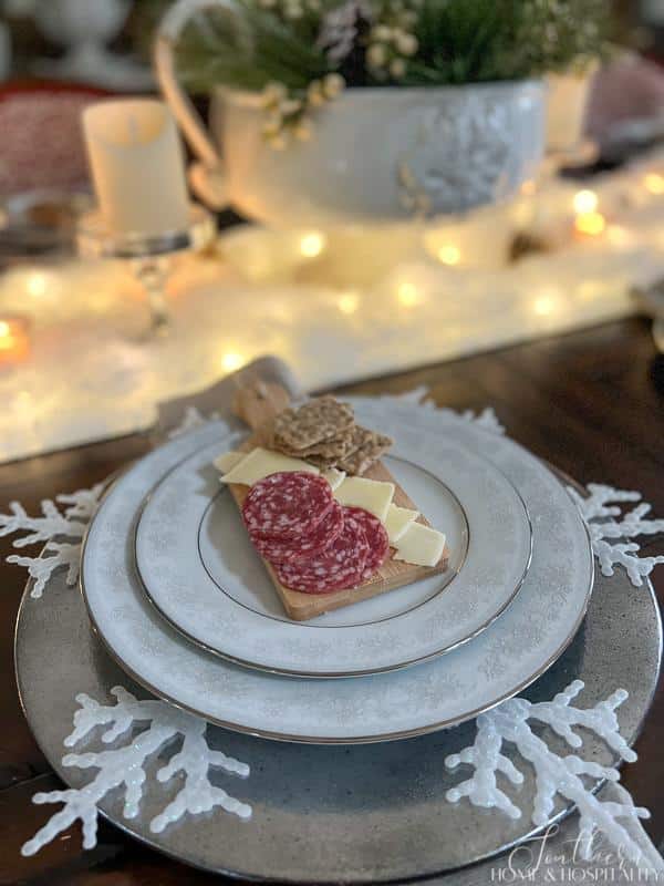 mini charcuterie board on place setting with snowflake and mercury glass charger