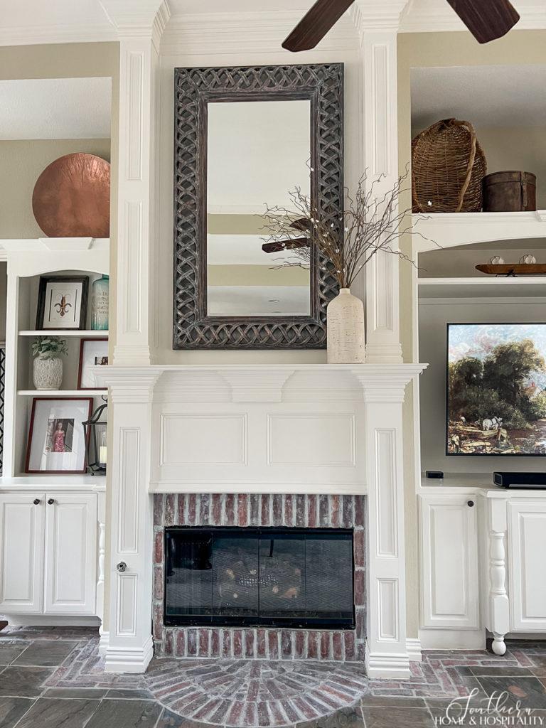 Traditional fireplace mantel with brick surround and brick arch hearth, painted wood paneling up to ceiling