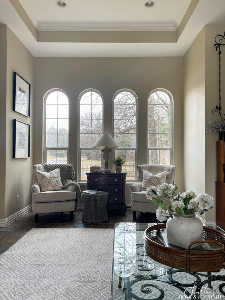 Traditional family room seating area with ivory upholstered chairs and arched windows