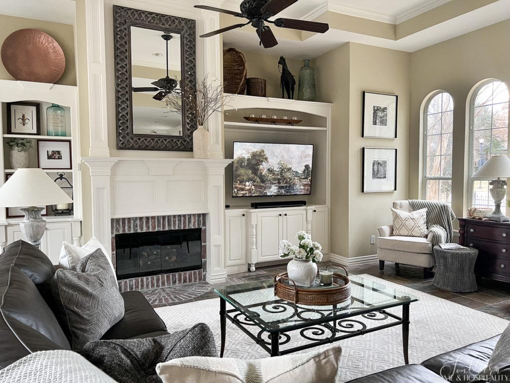 Traditional casual family room with painted built ins and brick fireplace surround, arched windows