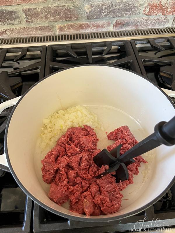 Cooking ground beef and onion with a meat chopper tool