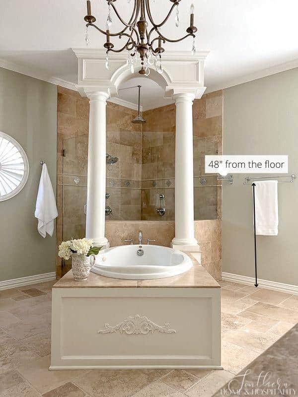 master bathroom with height for towel rod, travertine shower, chandelier over tub