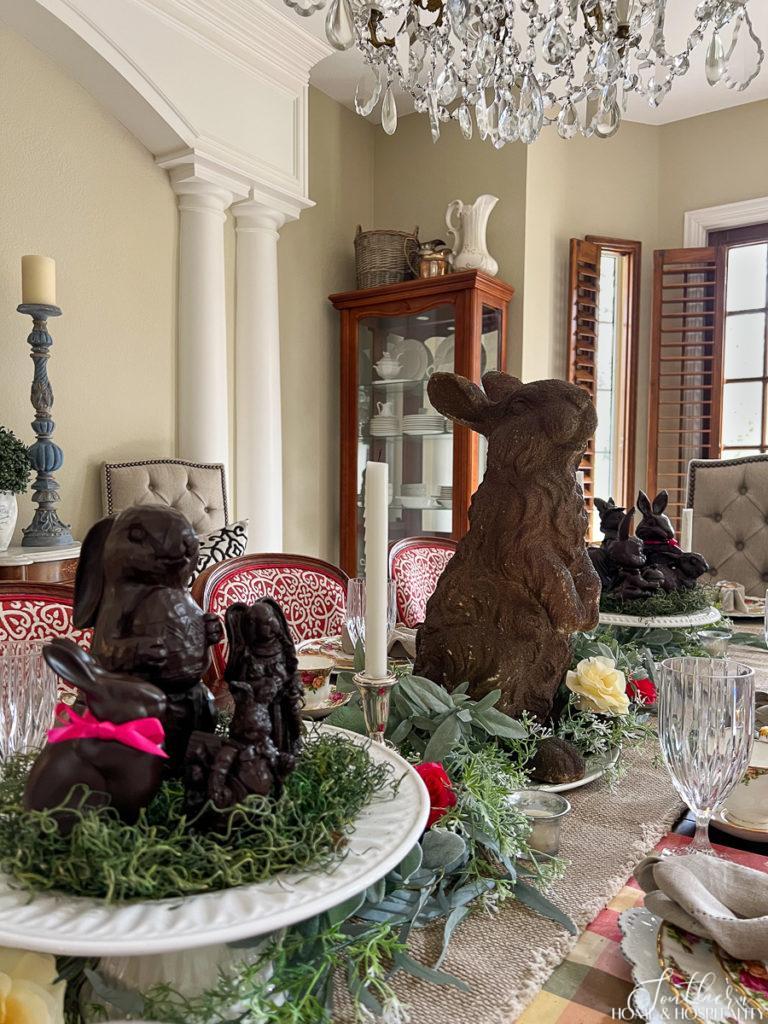 Faux chocolate bunnies in an Easter table centerpiece with rose and greenery garland