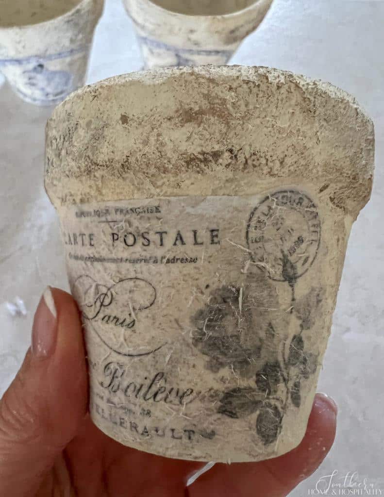 Peeling layers of paper off of French postcard image on flower pot