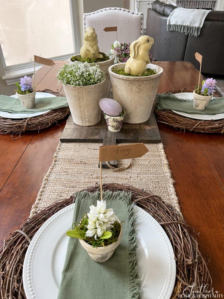 French farmhouse Easter tablescape with grapevine wreaths and flower pots