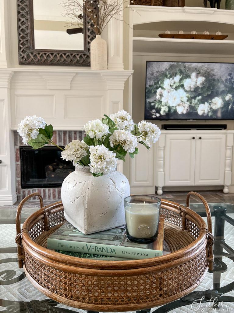 Cane and rattan coffee table tray with Veranda coffee table books and spring flowers