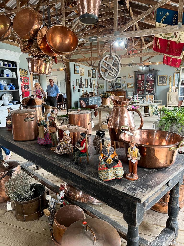 Copper pots and pitchers on a display table in Round Top