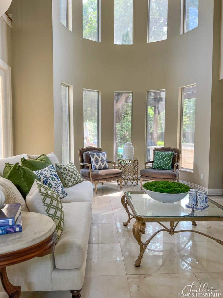 Neutral living room with pops of green and blue throw pillows and accessories