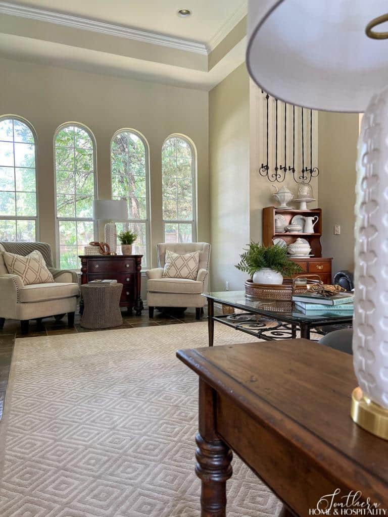 traditional neutral family room with leather sofa, glass coffee table and geometric area rug