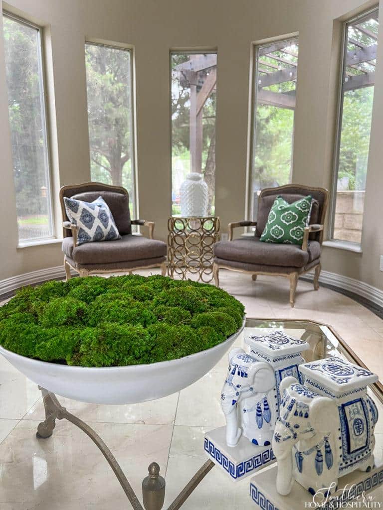moss bowl, blue and white porcelain elephants, bergere chairs, blue and green throw pillows