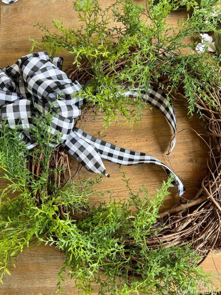 Buffalo check bow and airy greenery on grapevine wreath