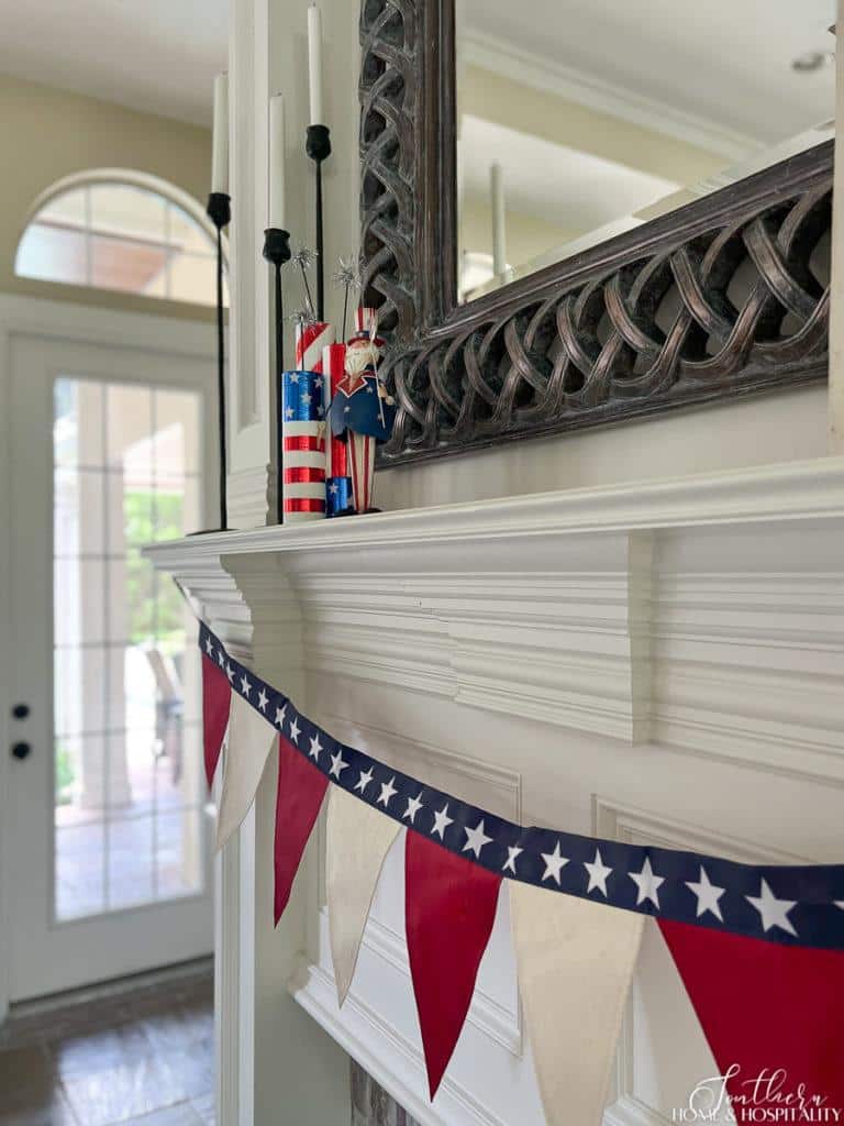 Fireplace mantel with red, white, and blue patriotic banner and 4th of July knick knacks