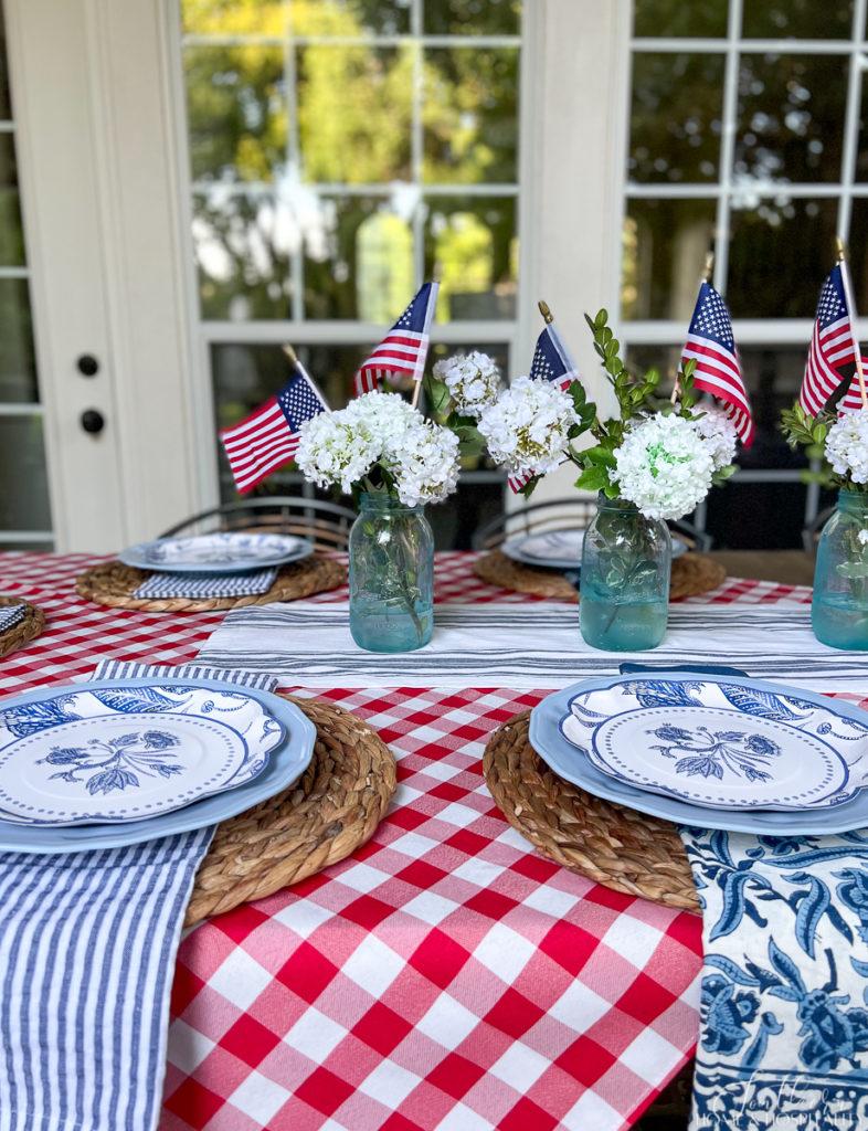 Blue and white seersucker and floral napkins, blue and white dishes in a 4th of July tablescape