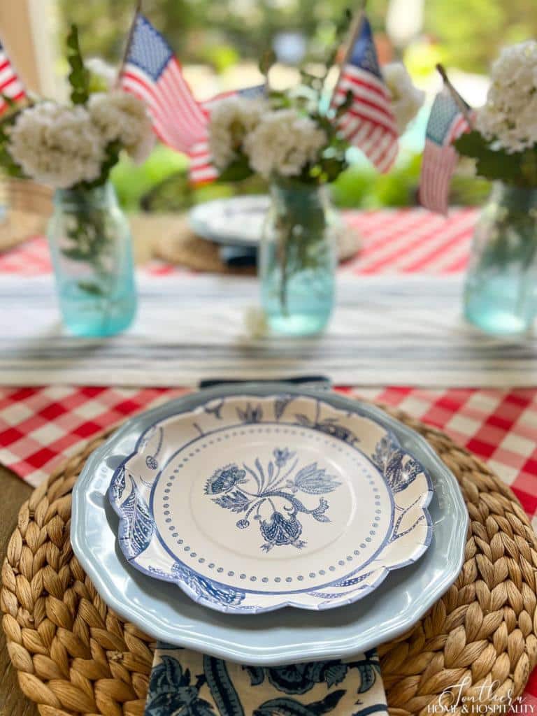 Blue and white floral dishes and fabric napkin in a 4th of July place setting